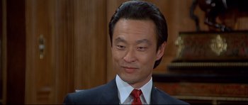 Movie still from “Licence to Kill” (1989), directed by John Glen – A person wearing a suit and tie; Close Up shot, High angle