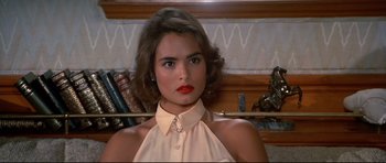 Movie still from “Licence to Kill” (1989), directed by John Glen – A woman with red lipstick holding onto a gold bar; Close Up shot, High angle
