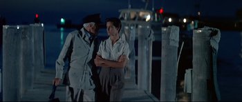 Movie still from “Licence to Kill” (1989), directed by John Glen – Two men standing on a dock at night; Medium shot, Low angle