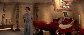 Movie still from “Licence to Kill” (1989), directed by John Glen – A woman standing in front of a boat in a room; Wide shot, Over the shoulder angle