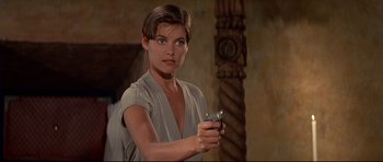 Movie still from “Licence to Kill” (1989), directed by John Glen – A woman holding a gun in a room with pillars; Close Up shot, Over the shoulder angle