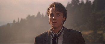 Movie still from “Licence to Kill” (1989), directed by John Glen – A man in a suit and tie looking at the camera; Close Up shot, Low angle
