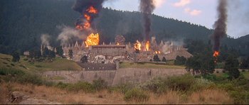 Movie still from “Licence to Kill” (1989), directed by John Glen – A large fire burning in the background of a town; Extreme Wide shot, High angle