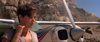 Movie still from “Licence to Kill” (1989), directed by John Glen – A woman standing in front of an airplane on the ground; Close Up shot, Low angle