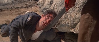 Movie still from “Licence to Kill” (1989), directed by John Glen – A man with blood on his face is holding a knife; Close Up shot, Overhead angle