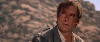 Movie still from “Licence to Kill” (1989), directed by John Glen – A person wearing a suit and tie; Close Up shot, Low angle