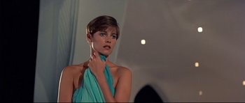 Movie still from “Licence to Kill” (1989), directed by John Glen – A woman with short hair wearing a blue dress; Close Up shot, Low angle