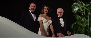 Movie still from “Licence to Kill” (1989), directed by John Glen – A group of people standing next to each other in tuxedos; Medium shot, Low angle