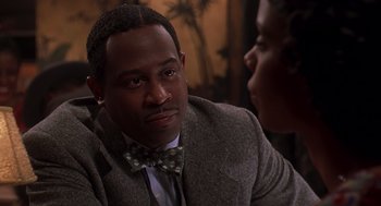 Movie still from “Life” (1999), directed by Ted Demme – A man wearing a suit and a bow tie talking to a woman; Close Up shot, Over the shoulder angle