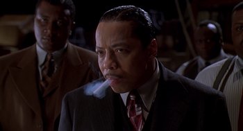 Movie still from “Life” (1999), directed by Ted Demme – A man in a suit and tie smoking a cigarette; Close Up shot, Low angle