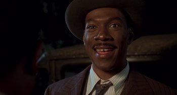 Movie still from “Life” (1999), directed by Ted Demme – A person wearing a suit and a hat; Close Up shot, Over the shoulder angle