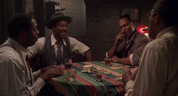 Movie still from “Life” (1999), directed by Ted Demme – A group of men sitting at a table with drinks; Medium shot, High angle