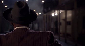 Movie still from “Life” (1999), directed by Ted Demme – A man wearing a hat standing in the dark; Close Up shot, Over the shoulder angle