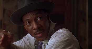 Movie still from “Life” (1999), directed by Ted Demme – A person wearing a hat and a tie; Close Up shot, Over the shoulder angle