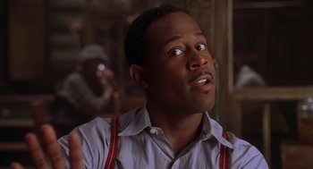 Movie still from “Life” (1999), directed by Ted Demme – A person holding a spoon; Close Up shot, Over the shoulder angle