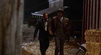 Movie still from “Life” (1999), directed by Ted Demme – A couple of men walking down a street at night holding hands; Medium shot, Low angle