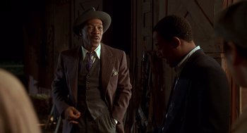 Movie still from “Life” (1999), directed by Ted Demme – A man in a suit and hat talking to another man in a suit and hat; Medium shot, Over the shoulder angle