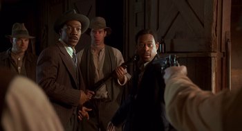 Movie still from “Life” (1999), directed by Ted Demme – A group of men standing next to each other holding guns; Medium shot, Over the shoulder angle