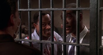 Movie still from “Life” (1999), directed by Ted Demme – Two young men are looking through the bars of a jail cell; Medium shot, Low angle