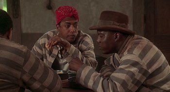 Movie still from “Life” (1999), directed by Ted Demme – A couple of men sitting next to each other at a table; Medium shot, High angle