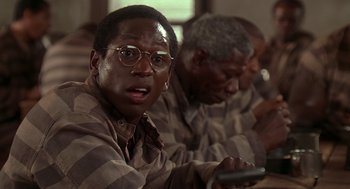 Movie still from “Life” (1999), directed by Ted Demme – A man with glasses is holding a cell phone; Close Up shot, High angle