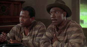 Movie still from “Life” (1999), directed by Ted Demme – A couple of men sitting next to each other in a room; Close Up shot, High angle