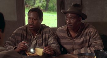 Movie still from “Life” (1999), directed by Ted Demme – A couple of men sitting next to each other at a table; Medium shot, High angle