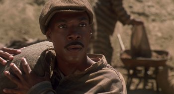 Movie still from “Life” (1999), directed by Ted Demme – A man in a hat and gloves looking at the camera; Close Up shot, Low angle