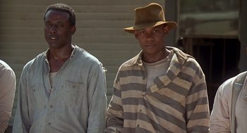 Movie still from “Life” (1999), directed by Ted Demme – Two men in striped shirts and a brown hat; Medium shot, Low angle