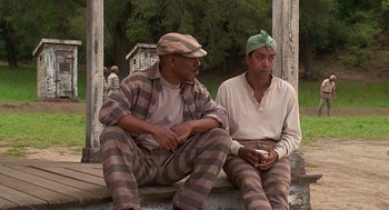 Movie still from “Life” (1999), directed by Ted Demme – A couple of men sitting next to each other on top of a porch; Medium shot, Low angle