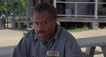 Movie still from “Life” (1999), directed by Ted Demme – An older man with a beard wearing a blue shirt; Close Up shot, Over the shoulder angle