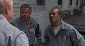 Movie still from “Life” (1999), directed by Ted Demme – A couple of men standing next to each other on a porch; Close Up shot, Over the shoulder angle
