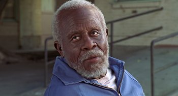 Movie still from “Life” (1999), directed by Ted Demme – An older man with a gray beard looking at the camera; Close Up shot, Low angle