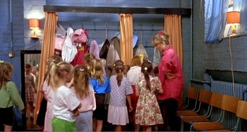 Movie still from “Life Is Sweet” (1990), directed by Mike Leigh – A group of children standing in front of a woman; Wide shot, High angle
