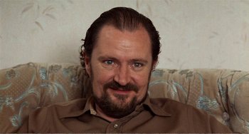 Movie still from “Life Is Sweet” (1990), directed by Mike Leigh – A person wearing a brown shirt; Close Up shot, Over the shoulder angle