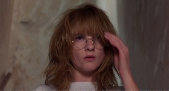 Movie still from “Life Is Sweet” (1990), directed by Mike Leigh – A woman with glasses is looking at the camera; Close Up shot, Low angle
