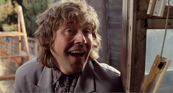 Movie still from “Life Is Sweet” (1990), directed by Mike Leigh – A person wearing a suit and tie; Close Up shot, Low angle