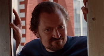 Movie still from “Life Is Sweet” (1990), directed by Mike Leigh – A person with a beard; Close Up shot, Low angle