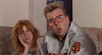 Movie still from “Life Is Sweet” (1990), directed by Mike Leigh – A man and a woman wearing red glasses and a silver jacket; Close Up shot, Low angle