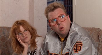 Movie still from “Life Is Sweet” (1990), directed by Mike Leigh – A man and a woman wearing red glasses; Close Up shot, Low angle