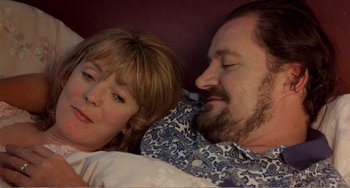 Movie still from “Life Is Sweet” (1990), directed by Mike Leigh – A man and a woman laying in bed together; Close Up shot, High angle