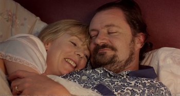 Movie still from “Life Is Sweet” (1990), directed by Mike Leigh – A man and a woman laying in bed together; Close Up shot, Overhead angle