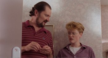 Movie still from “Life Is Sweet” (1990), directed by Mike Leigh – A man standing next to a woman wearing glasses; Close Up shot, Over the shoulder angle