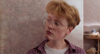 Movie still from “Life Is Sweet” (1990), directed by Mike Leigh – A young man with glasses looking to his left; Close Up shot, Low angle