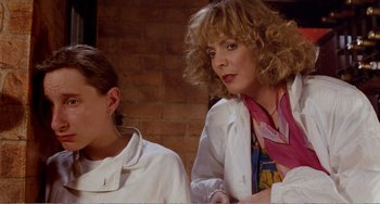 Movie still from “Life Is Sweet” (1990), directed by Mike Leigh – A woman and a boy sitting next to a brick wall; Close Up shot, Low angle
