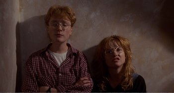 Movie still from “Life Is Sweet” (1990), directed by Mike Leigh – A couple of people that are sitting next to each other; Medium shot, Low angle