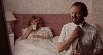 Movie still from “Life Is Sweet” (1990), directed by Mike Leigh – A man and a woman sitting in a bed drinking coffee; Medium shot, Over the shoulder angle