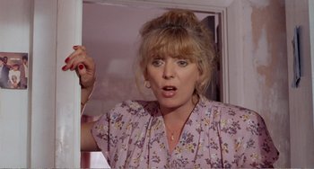 Movie still from “Life Is Sweet” (1990), directed by Mike Leigh – A woman in a pink floral shirt looking at a mirror; Close Up shot, Over the shoulder angle