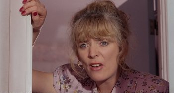 Movie still from “Life Is Sweet” (1990), directed by Mike Leigh – A person wearing a pink shirt; Close Up shot, Low angle