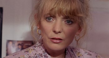 Movie still from “Life Is Sweet” (1990), directed by Mike Leigh – A person wearing a floral shirt; Close Up shot, High angle